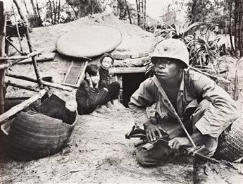 (VIETNAM WAR) A group of approximately 67 press photographs on the ground in Vietnam.